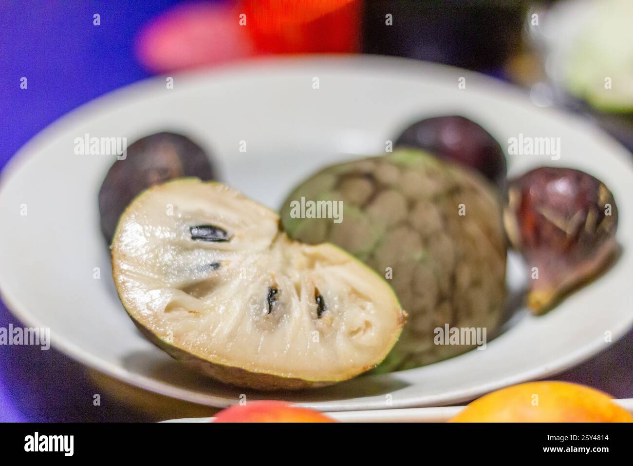 Ein Teller mit frischen Feigen und Cherimoya, serviert in Terrassa, Spanien, eine süße und saisonale Fruchtkombination, die in mediterranen Häusern beliebt ist Stockfoto