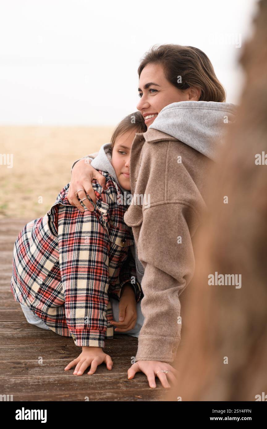 Mutter und Tochter sitzen am Strand Stockfoto