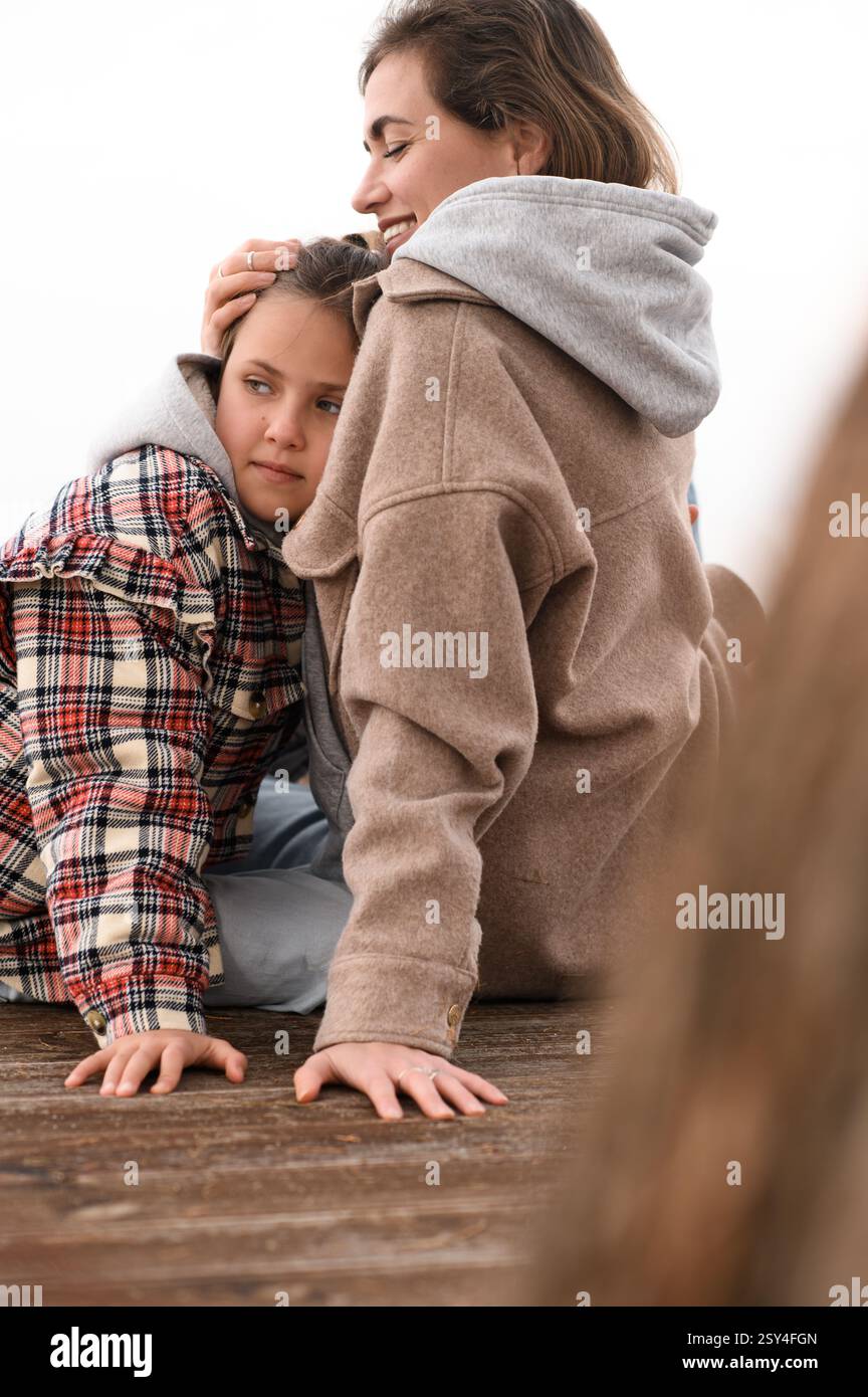 Mutter und Tochter sitzen am Strand Stockfoto