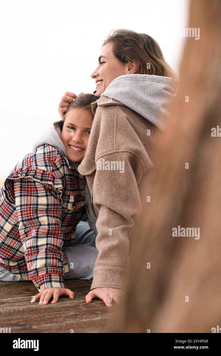 Mutter und Tochter sitzen am Strand Stockfoto