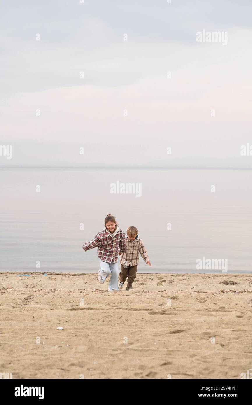 Bruder und Schwester umarmen sich am Strand nahe am Meer Stockfoto