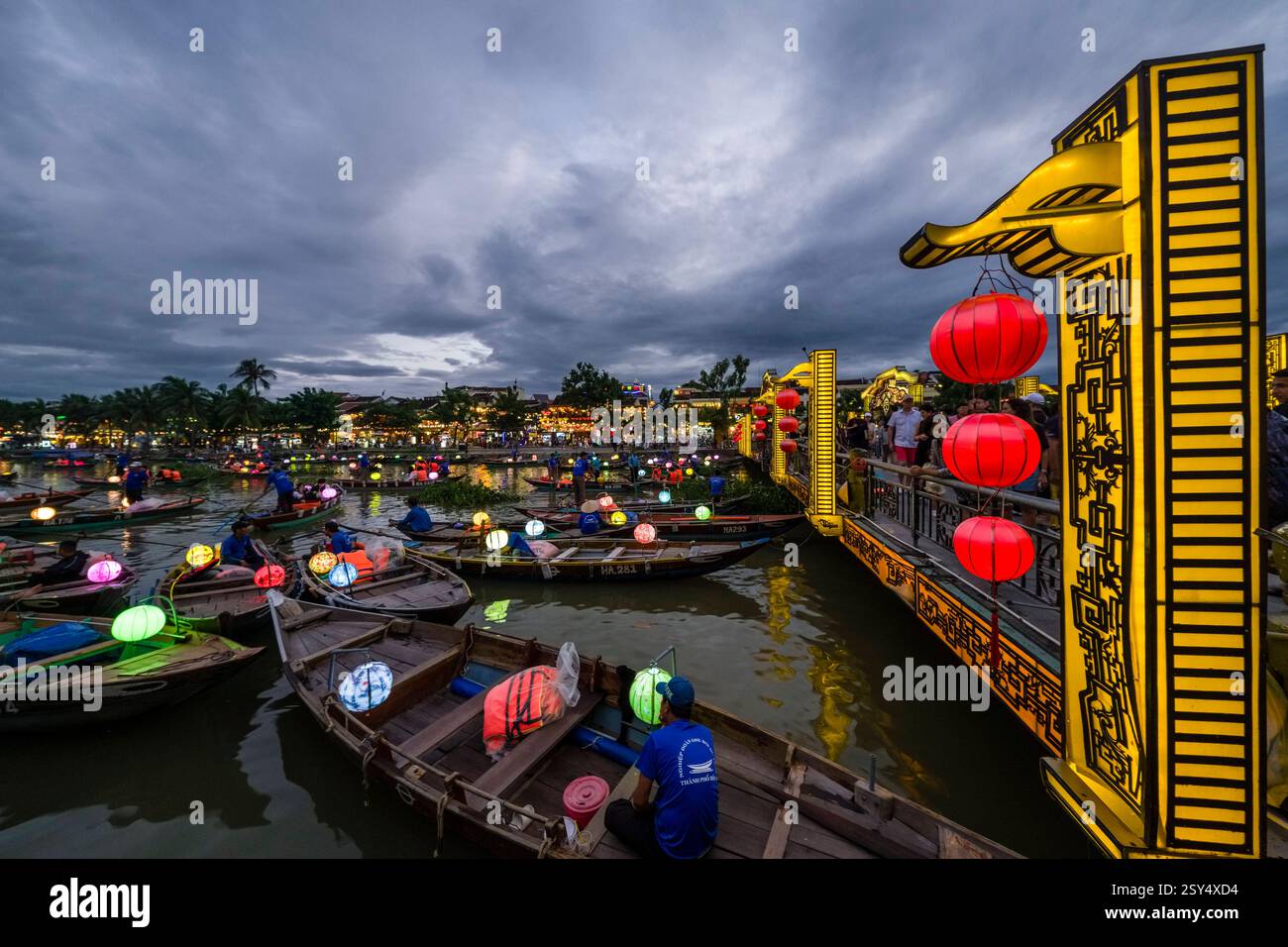 Touristen auf einer Fußgängerbrücke in Hoi an, Hái an und viele Boote mit Laternen während einer abendlichen Kreuzfahrt auf dem Fluss Thu Bon, SÃ ng Thu Bá n. Hoi an Q Stockfoto