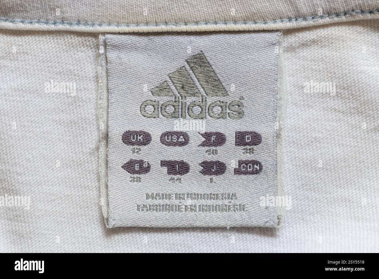 Adidas-Label in einem Frauen-T-Shirt, Bekleidungsanhänger mit Größen in verschiedenen Ländern, hergestellt in Indonesien Stockfoto