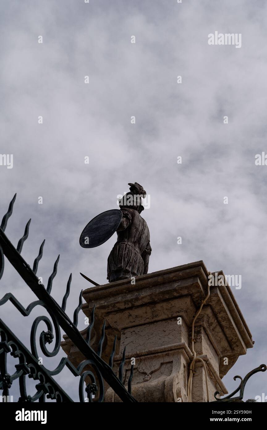 Eine verwitterte Soldatenstatue mit Schild und Schwert steht auf einer kunstvollen Torsäule der Palácio Fronteira Stockfoto
