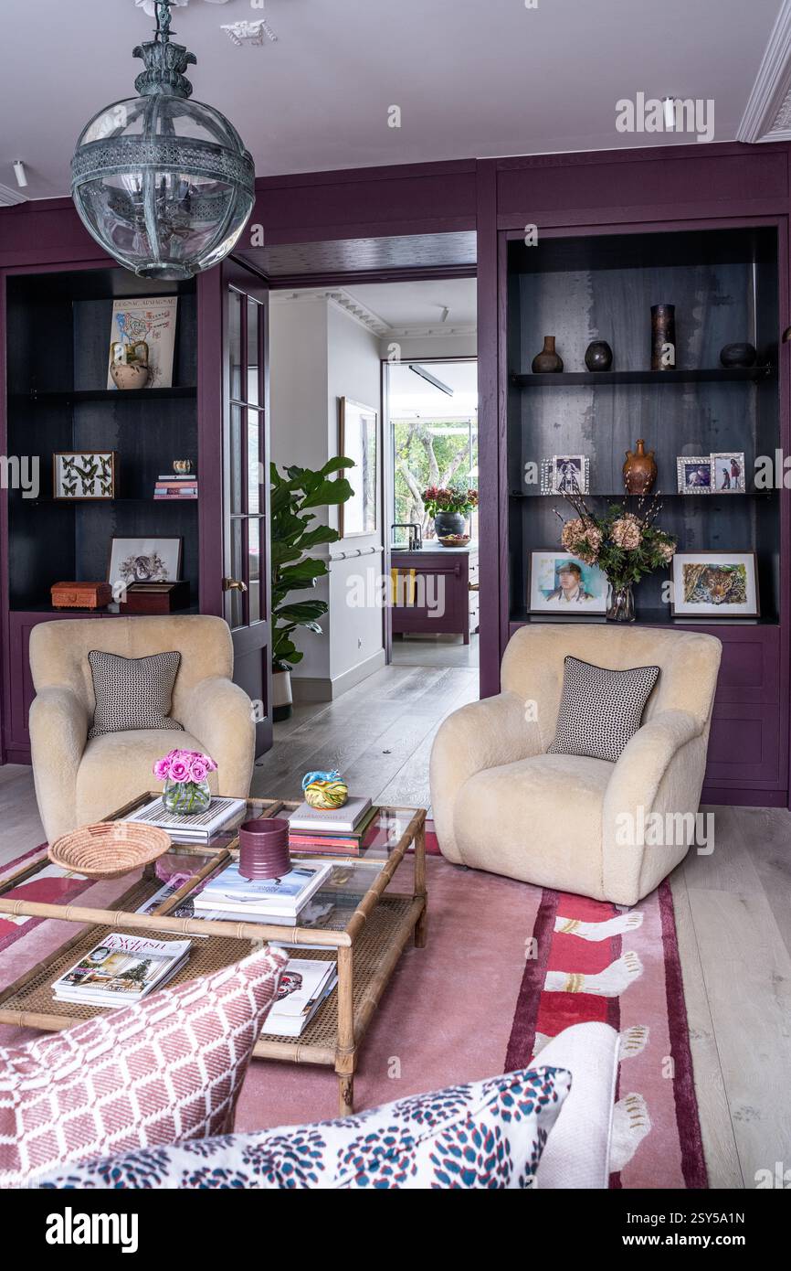 Zwei Sessel mit neuseeländischem Lammfell und Aubergine-Anstrich im zeitgenössischen Neudesign des Hauses West London. Stockfoto