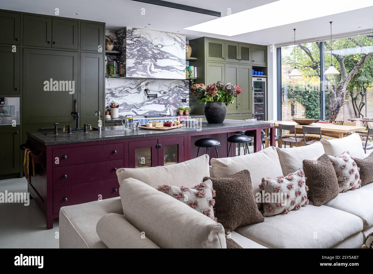 Geräumige Küche mit Auberginen- und olivgrünen Anstrichen im zeitgenössischen Neudesign des Hauses West London. Stockfoto
