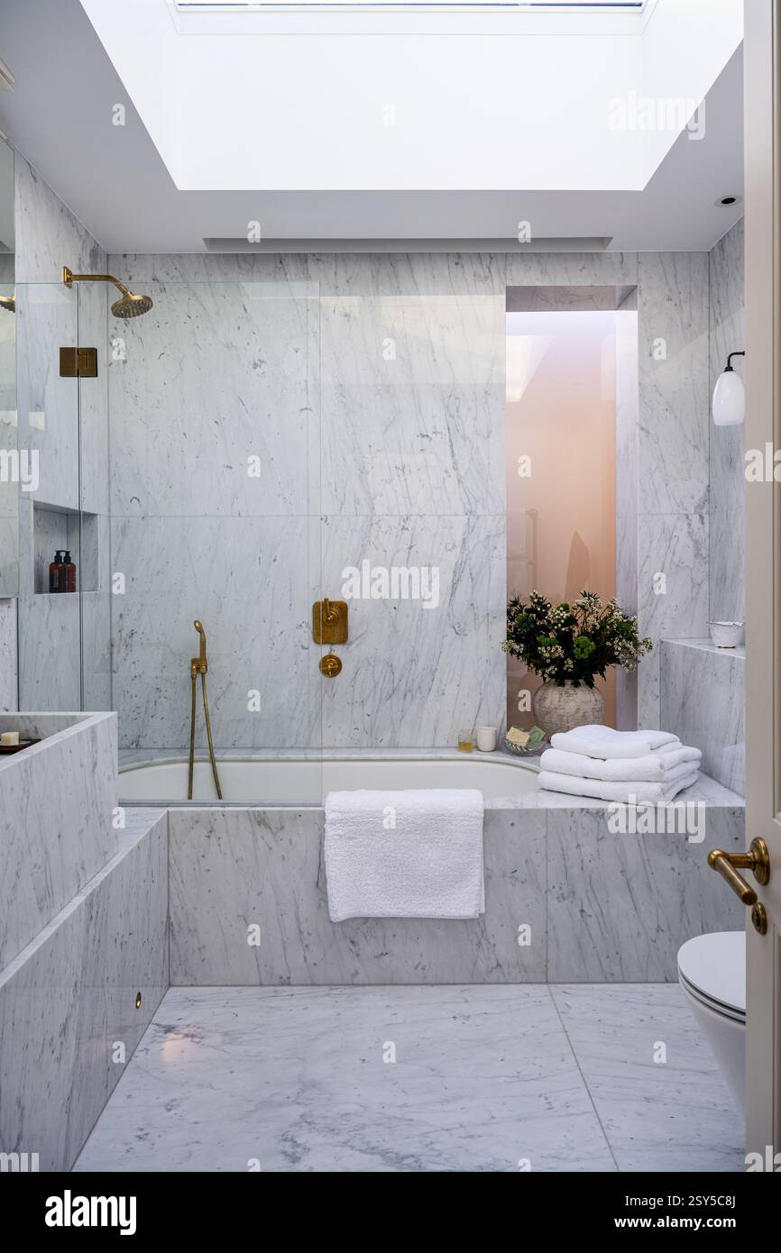 Gefaltete Handtücher auf Marmorbadezimmer umgeben von einem zeitgenössischen Neudesign des Hauses West London. Stockfoto