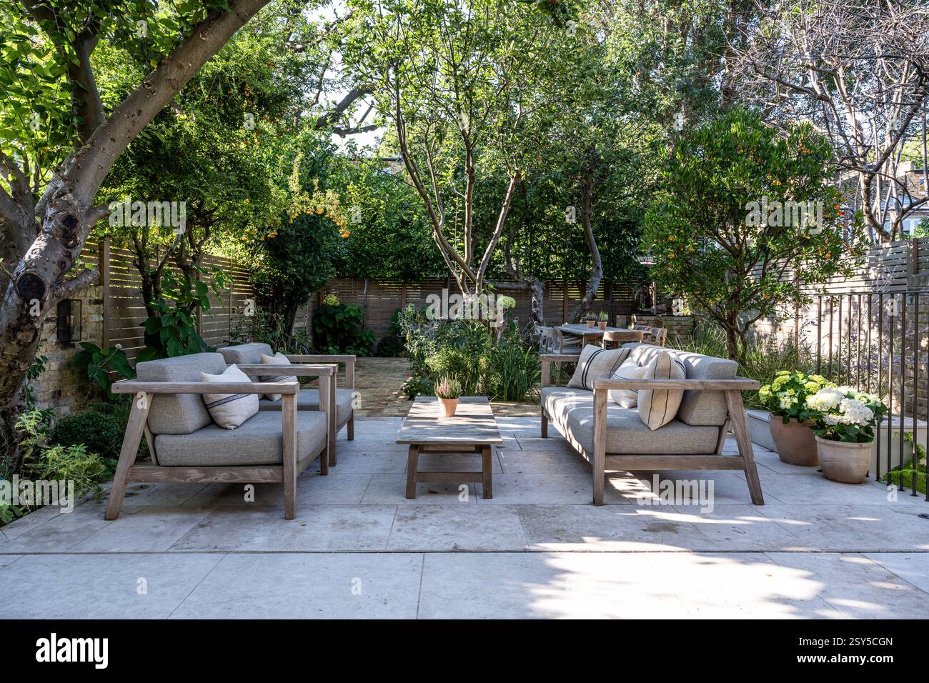 Gepflasterte Gartenterrasse und Sitzgelegenheiten für pflegeleichte, zeitgemäße Neugestaltung des Hauses West London. Gartendesign von Amelia Bouquet. Stockfoto