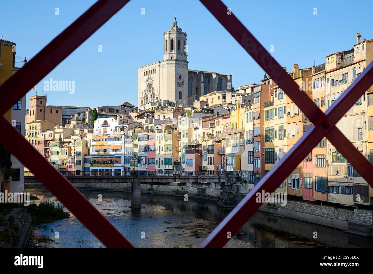Girona, Spanien - 29.07.2024: Bunte Häuser entlang des Onyar-Flusses, der durch die Stadt fließt mit Blick auf die Basilika Sant Feliu. Stockfoto