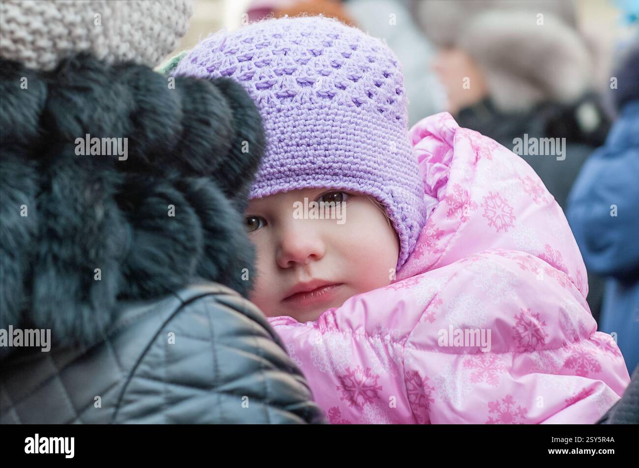 Kolomna, Russland, 8. Januar 2015. Trauriges gefrorenes Mädchen von 2-3 Jahren auf der Schulter ihrer Eltern. Weihnachtsprozession in Kolomna. Stockfoto