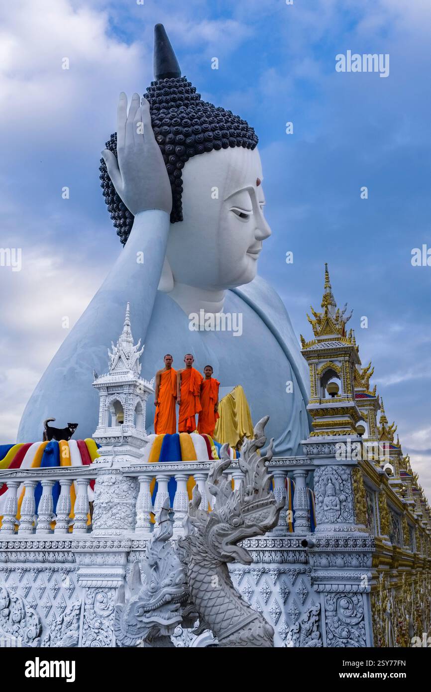 Drei buddhistische Mönche stehen vor der 63 Meter langen Statue eines liegenden Buddha in der Som Rong-Pagode, Chùa Som Rong, einem berühmten spirituellen Ort Stockfoto