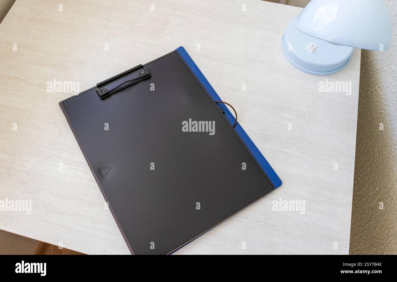 Aufnahme der Plastikmappe auf dem Schreibtisch mit Büroklammerhalter oben Stockfoto