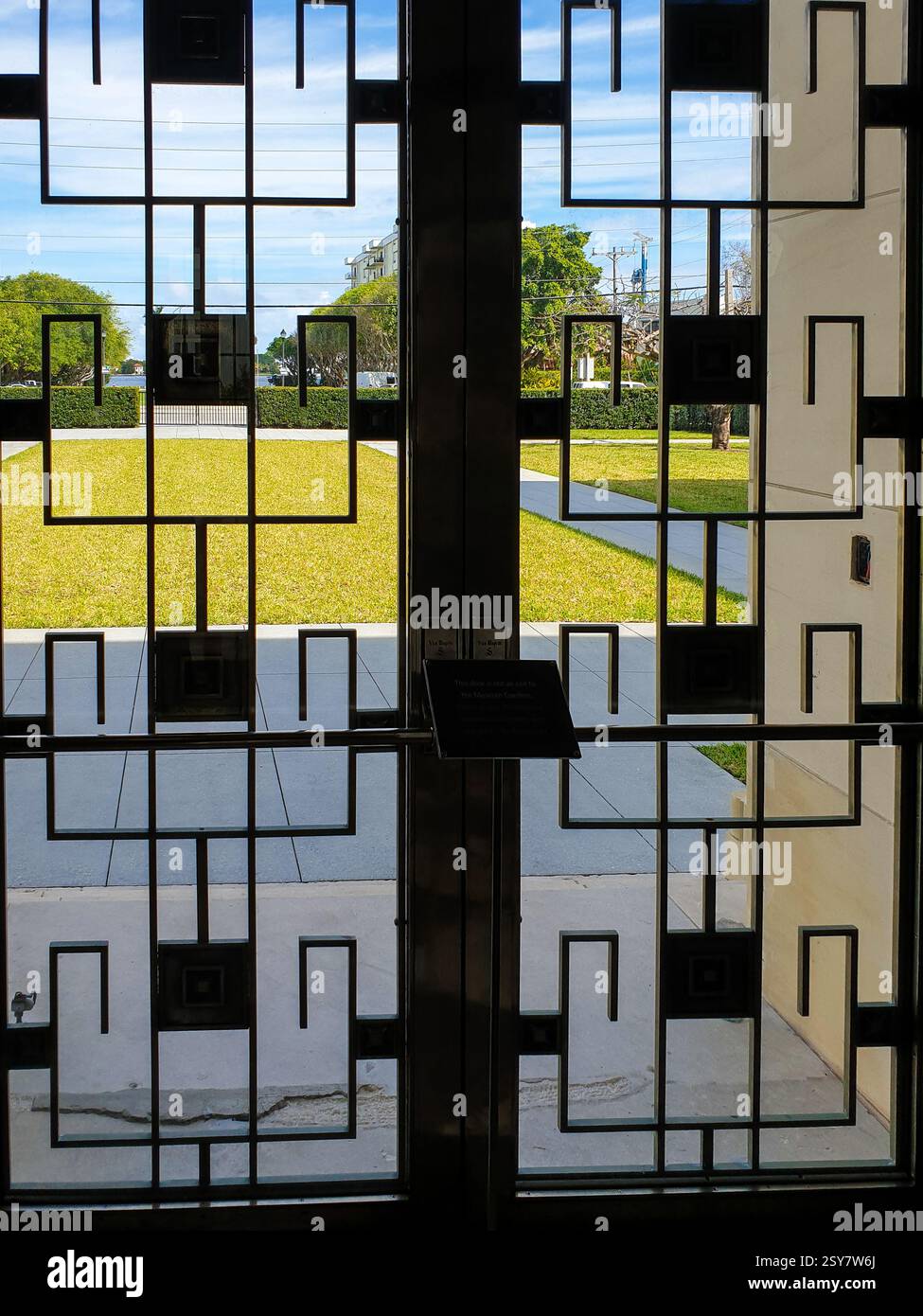 Blick auf den Garten durch eine Metalltür. Stockfoto