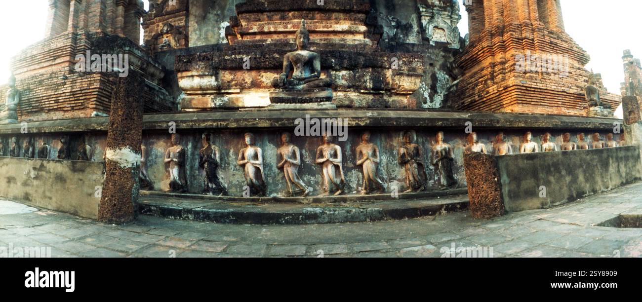 Panoramablick auf Statuen, die an der alten Mauer des ruinierten Tempels gemeißelt wurden, Sukhothai Historical Park, Sukhothai, Thailand Stockfoto