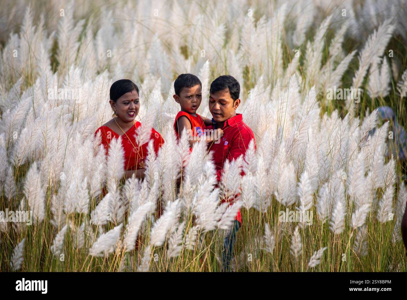 Die Menschen tauchen ein in die Schönheit der blühenden Kans-Grasblumen und feiern das Wesen des Herbstes am Stadtrand von Dhaka, Bangladesch. Stockfoto
