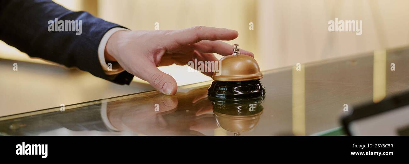 Website-Banner mit nicht erkennbaren männlichen Handklingeln an der Rezeption im Hotel Stockfoto