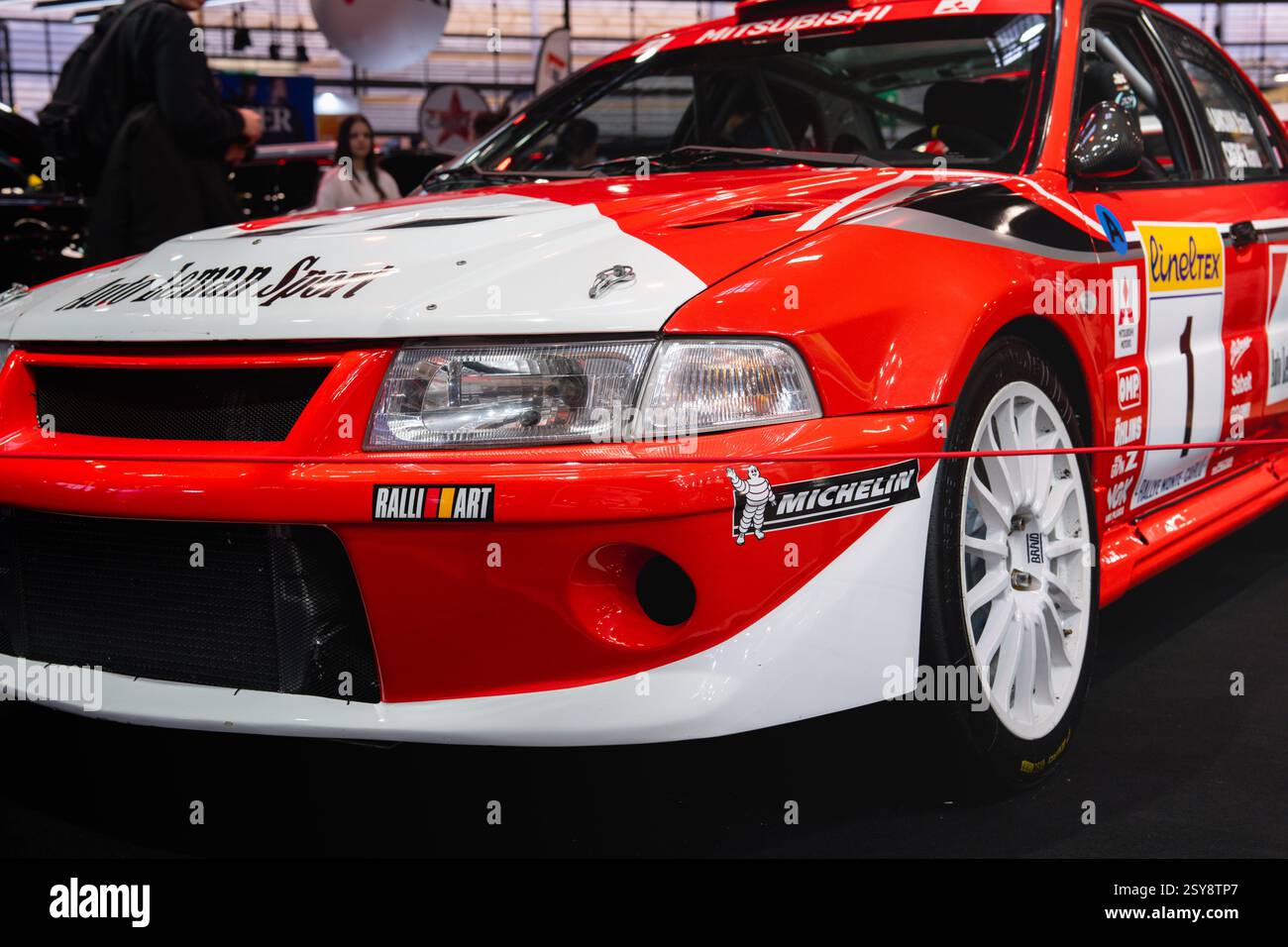 Das auf der Motorsport expo präsentierte Rallyefahrzeug in Rot und weiß präsentiert sich mit leistungsstarker Technik und faszinierendem Design Stockfoto