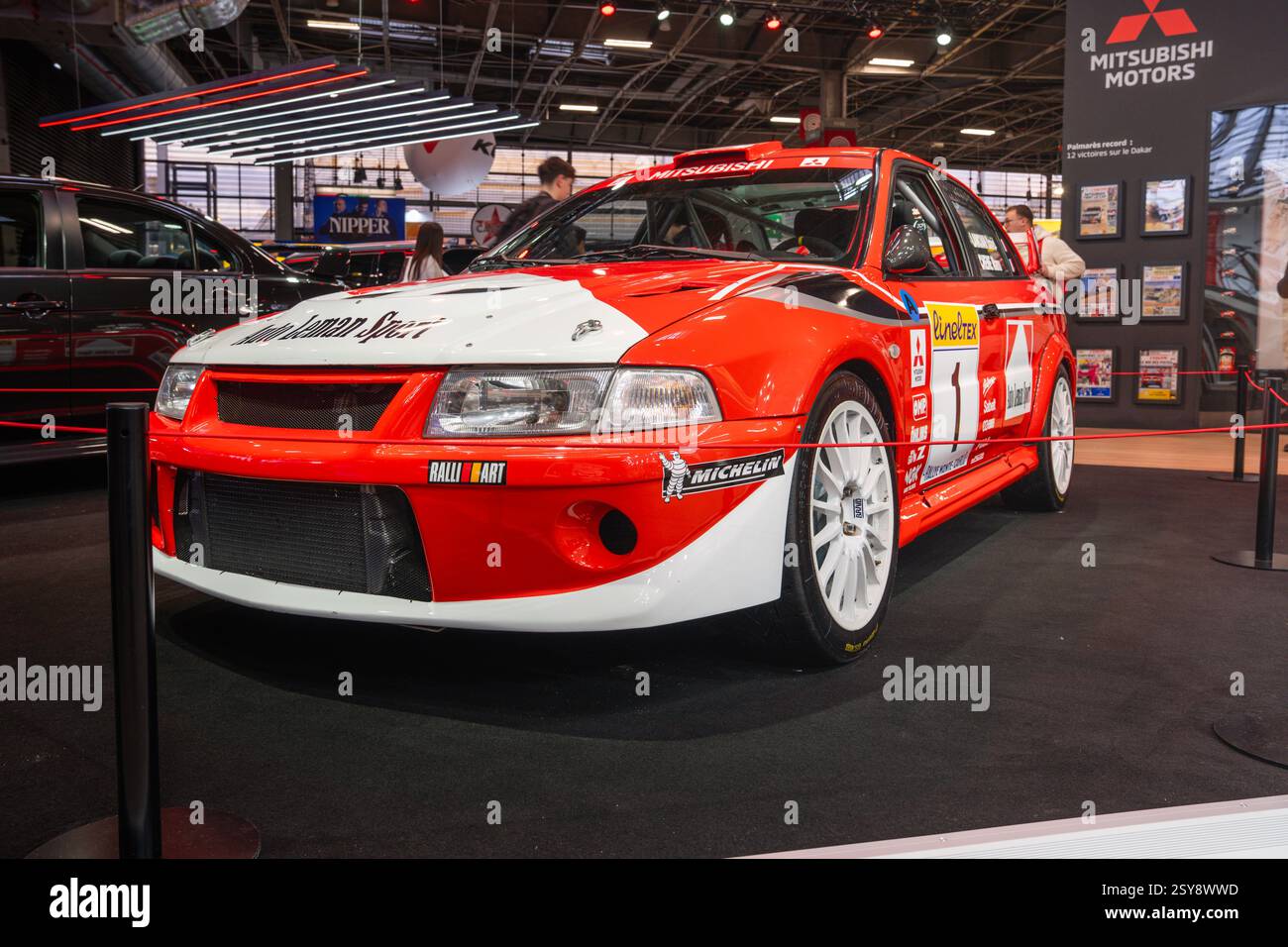 Legendäres Rallyefahrzeug, das auf einer Automobilausstellung präsentiert wird, in kräftigen Farben und schlankem Design in einem lebendigen Innenraum Stockfoto