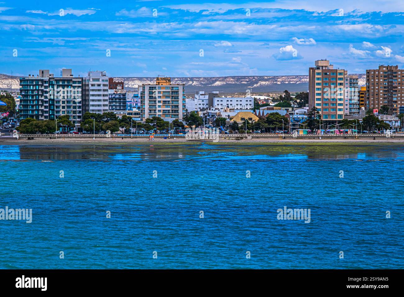 Puerto Madryn, Argentinien - 17. Dezember 2024: Die Reflexionen der Hochhäuser spiegeln sich entlang der Uferpromenade. Stockfoto
