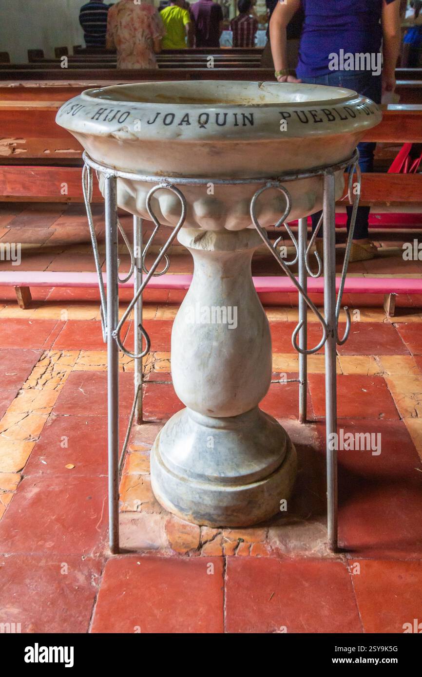 Antike Marmor-Weihwasserfontäne mit kunstvollen Schnitzereien in der Jimenez Church Mindanao Philippines, hergestellt im Jahr 1878 Stockfoto