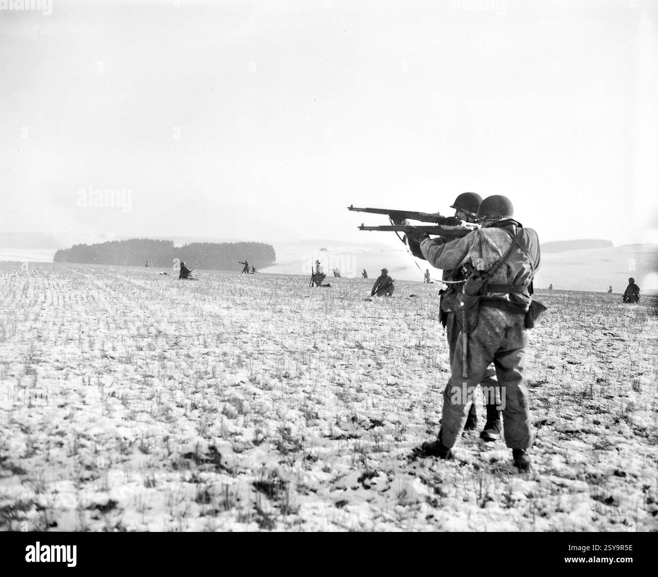 US-Infanteristen, die der 4. Panzerdivision angehören, feuern auf deutsche Truppen, im amerikanischen Vormarsch, um den Druck auf umschlossene Luftlandetruppen zu verringern, Bastogne, Belgien, Signal Corps der US-Armee, 27. Dezember 1944 Stockfoto
