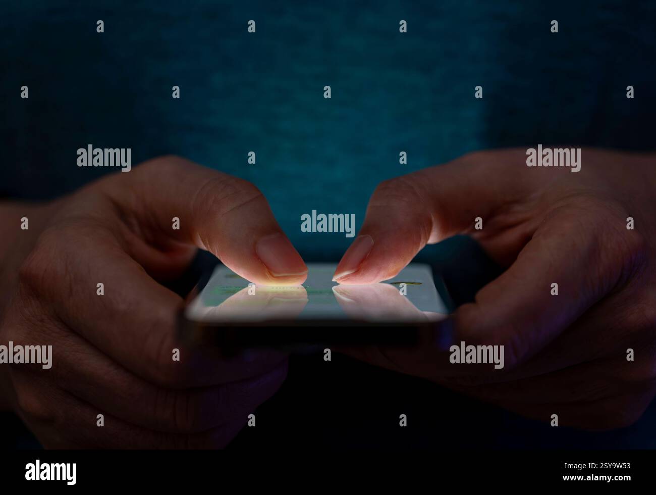 27.02.2025, Thema Smartphone-Nutzung, Frau tippt auf einem Apple iPhone13 Smartphone-Screen SMS. Das Bild zeigt eine Person, die in einer schlecht beleuchteten Umgebung ein Smartphone benutzt. Die Beleuchtung hebt die Finger des Benutzers und den Bildschirm des Smartphones hervor. 27.02.2025, Smartphone 27.02.2025, Smartphone *** 27 02 2025, Thema Smartphone-Nutzung, Frau, die auf einem Apple iPhone13 Smartphone-Bildschirm SMS tippt das Bild zeigt eine Person, die ein Smartphone in einer schlecht beleuchteten Umgebung verwendet. Die Beleuchtung hebt die Finger des Benutzers und den Smartphone-Bildschirm hervor 27 02 2025, Smartphone 27 02 2025, SMA Stockfoto