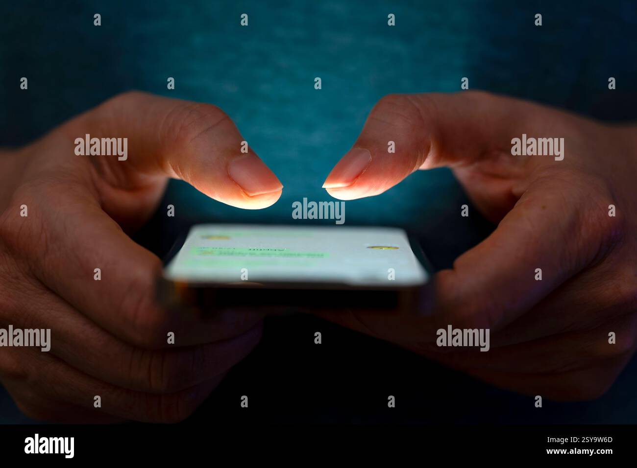 27.02.2025, Thema Smartphone-Nutzung, Frau tippt auf einem Apple iPhone13 Smartphone-Screen SMS. Das Bild zeigt eine Person, die in einer schlecht beleuchteten Umgebung ein Smartphone benutzt. Die Beleuchtung hebt die Finger des Benutzers und den Bildschirm des Smartphones hervor. 27.02.2025, Smartphone 27.02.2025, Smartphone *** 27 02 2025, Thema Smartphone-Nutzung, Frau, die auf einem Apple iPhone13 Smartphone-Bildschirm SMS tippt das Bild zeigt eine Person, die ein Smartphone in einer schlecht beleuchteten Umgebung verwendet. Die Beleuchtung hebt die Finger des Benutzers und den Smartphone-Bildschirm hervor 27 02 2025, Smartphone 27 02 2025, SMA Stockfoto