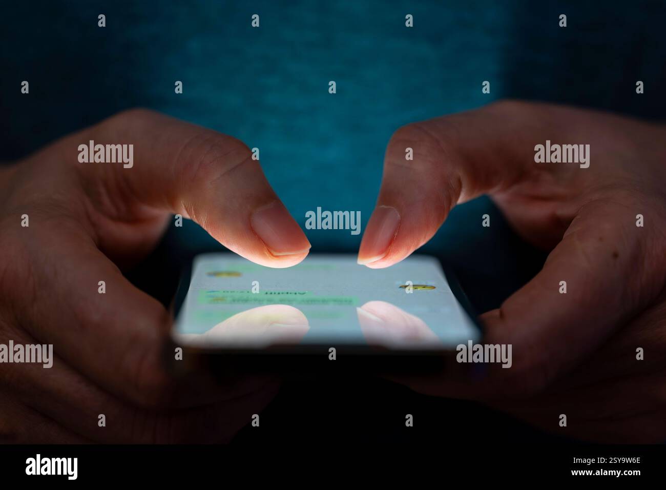 27.02.2025, Thema Smartphone-Nutzung, Frau tippt auf einem Apple iPhone13 Smartphone-Screen SMS. Das Bild zeigt eine Person, die in einer schlecht beleuchteten Umgebung ein Smartphone benutzt. Die Beleuchtung hebt die Finger des Benutzers und den Bildschirm des Smartphones hervor. 27.02.2025, Smartphone 27.02.2025, Smartphone *** 27 02 2025, Thema Smartphone-Nutzung, Frau, die auf einem Apple iPhone13 Smartphone-Bildschirm SMS tippt das Bild zeigt eine Person, die ein Smartphone in einer schlecht beleuchteten Umgebung verwendet. Die Beleuchtung hebt die Finger des Benutzers und den Smartphone-Bildschirm hervor 27 02 2025, Smartphone 27 02 2025, SMA Stockfoto