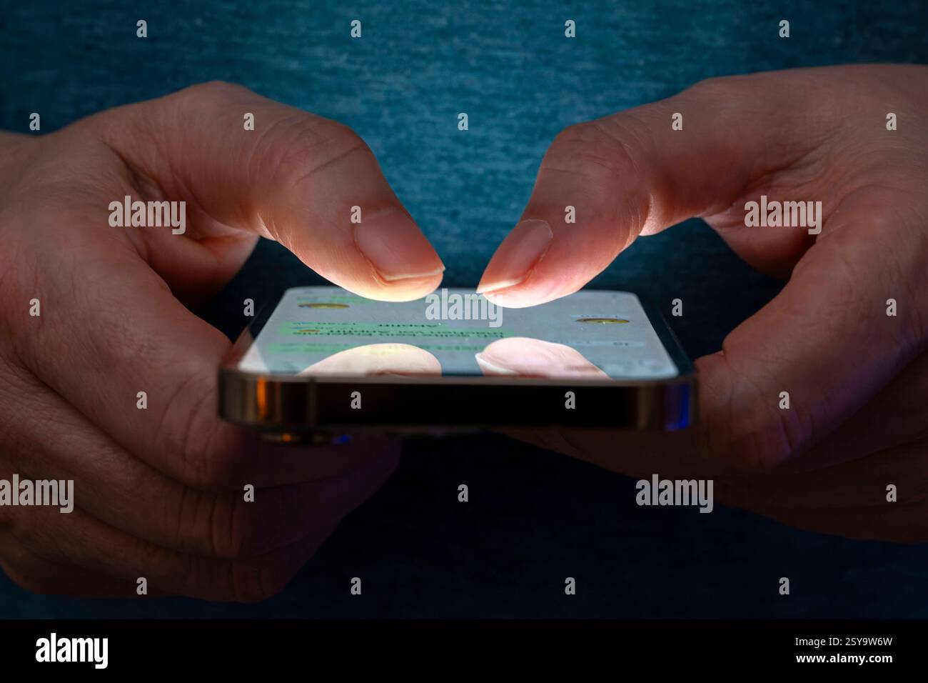 27.02.2025, Thema Smartphone-Nutzung, Frau tippt auf einem Apple iPhone13 Smartphone-Screen SMS. Das Bild zeigt eine Person, die in einer schlecht beleuchteten Umgebung ein Smartphone benutzt. Die Beleuchtung hebt die Finger des Benutzers und den Bildschirm des Smartphones hervor. 27.02.2025, Smartphone 27.02.2025, Smartphone *** 27 02 2025, Thema Smartphone-Nutzung, Frau, die auf einem Apple iPhone13 Smartphone-Bildschirm SMS tippt das Bild zeigt eine Person, die ein Smartphone in einer schlecht beleuchteten Umgebung verwendet. Die Beleuchtung hebt die Finger des Benutzers und den Smartphone-Bildschirm hervor 27 02 2025, Smartphone 27 02 2025, SMA Stockfoto