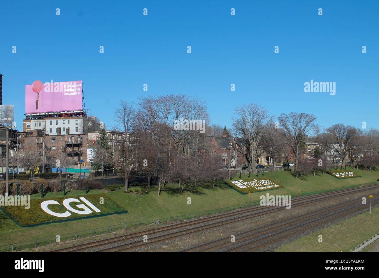 Toronto, Kanada. 9. April 2017: Stadtlandschaft Toronto mit Eisenbahngleisen und dekorativem CGI-Logo auf grasbewachsenem Damm Stockfoto