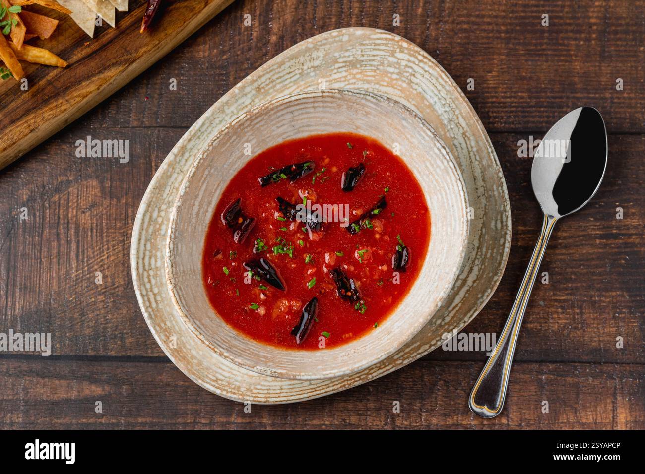 Scharfe mexikanische Tomatensuppe mit getrockneten Chilischoten in einer rustikalen Schüssel Stockfoto
