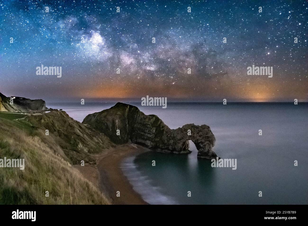 Durdle Door, Dorset, Großbritannien. Februar 2025. Wetter in Großbritannien. Der galaktische Kern der Milchstraße leuchtet am letzten Tag des meteorologischen Winters hell im klaren Winterhimmel über Durdle Door in Dorset Stockfoto