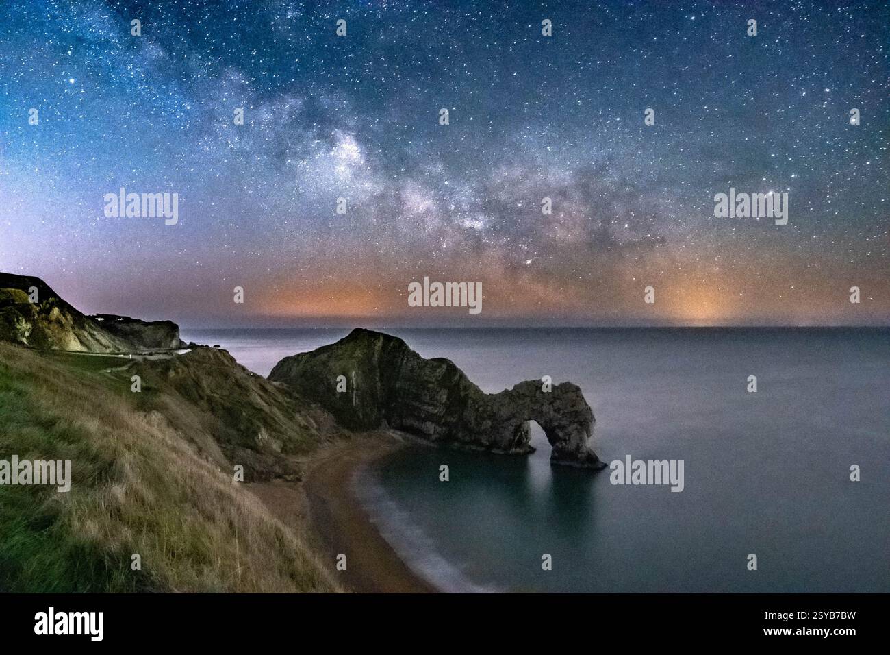 Durdle Door, Dorset, Großbritannien. Februar 2025. Wetter in Großbritannien. Der galaktische Kern der Milchstraße leuchtet am letzten Tag des meteorologischen Winters hell im klaren Winterhimmel über Durdle Door in Dorset Stockfoto
