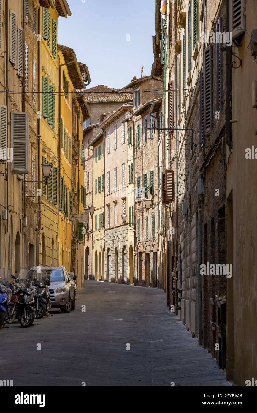 Blick auf eine kleine Straße, die durch alte Gebäude in der Stadt Siena, Toskana, Italien, Europa führt Stockfoto