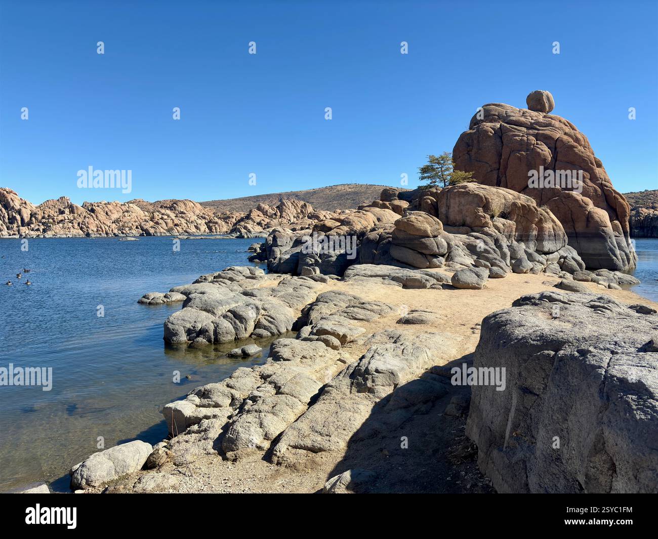 Felsige Küste des Watson Lake in Prescott, Arizona, mit ruhigem blauem Wasser Stockfoto