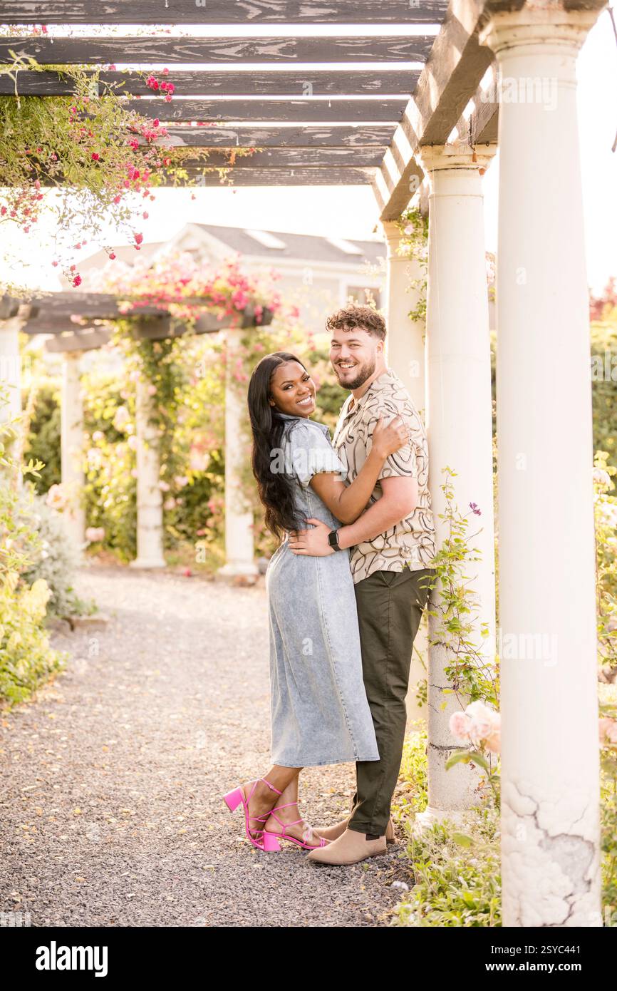 Zusammen lächeln unter einer schönen Gartenpergola Stockfoto