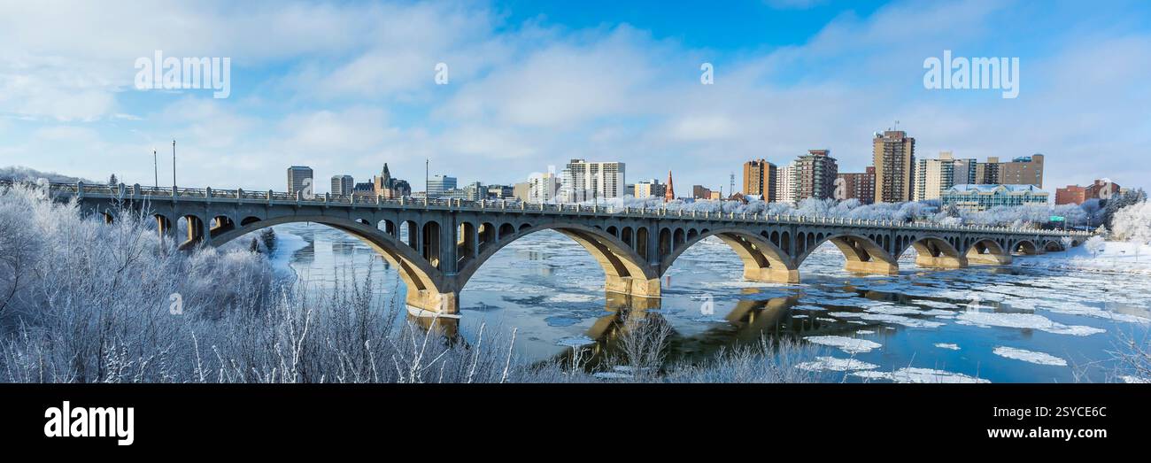 Brücke über einen Fluss mit Schnee auf den Bäumen. Die Brücke liegt mitten in einer Stadt Stockfoto