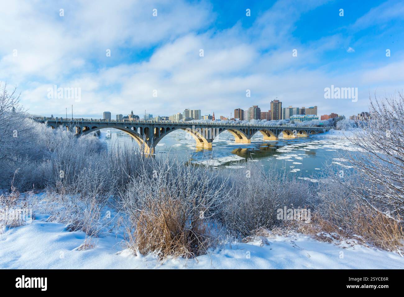 Brücke über einen Fluss mit Schnee auf dem Boden. Die Brücke liegt mitten in einer Stadt Stockfoto