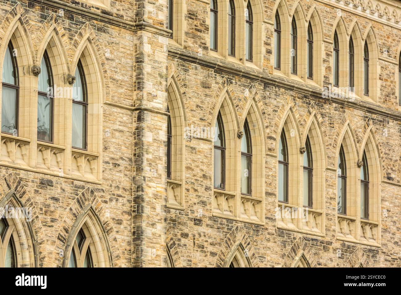 Gebäude mit Bogenfenstern und einer Steinfassade. Die Fenster sind groß und das Gebäude ist hoch Stockfoto