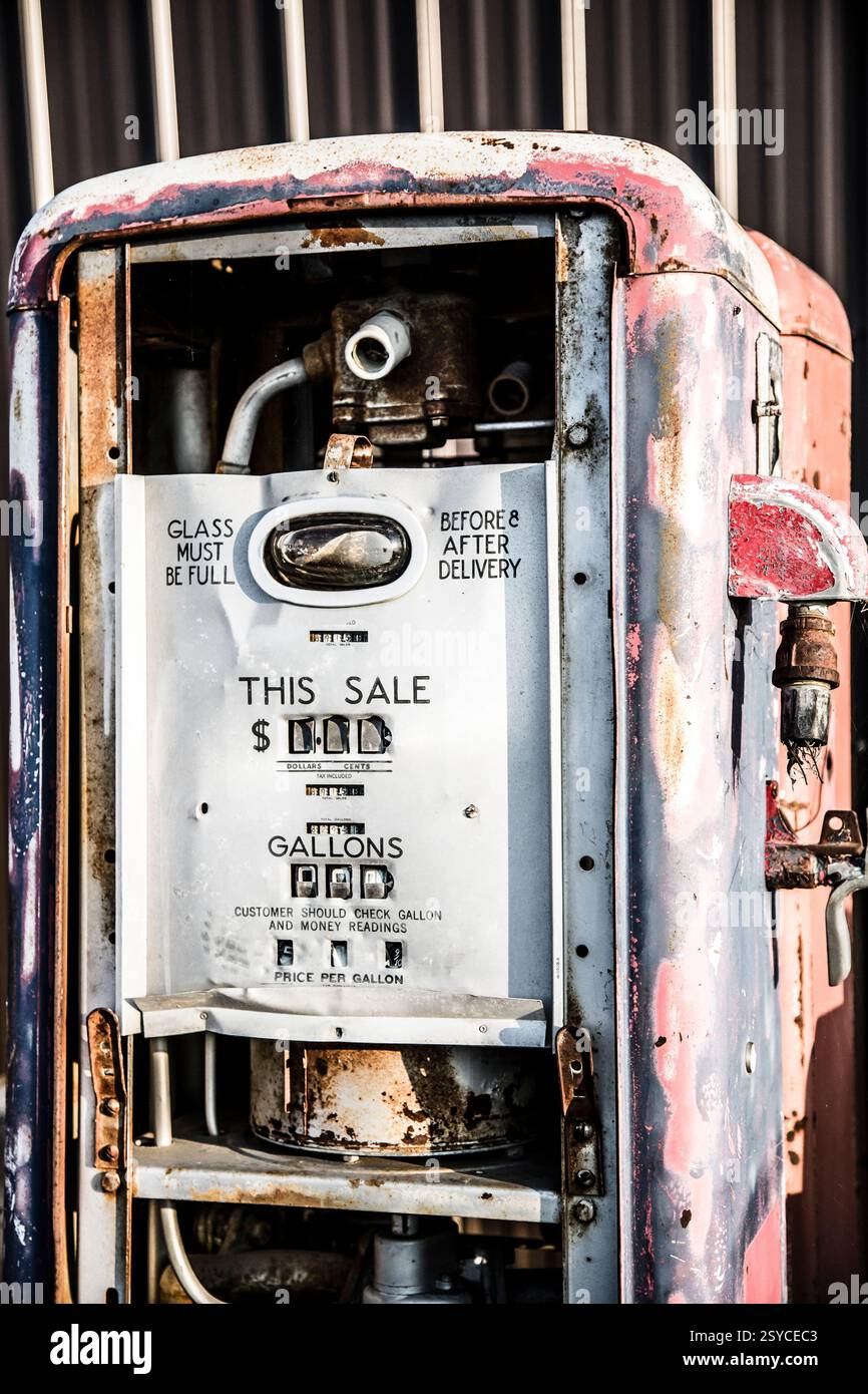 Eine alte Tankstelle mit einem Schild, auf dem steht "dieser Verkauf". Die Station ist rostig und hat ein paar Löcher Stockfoto