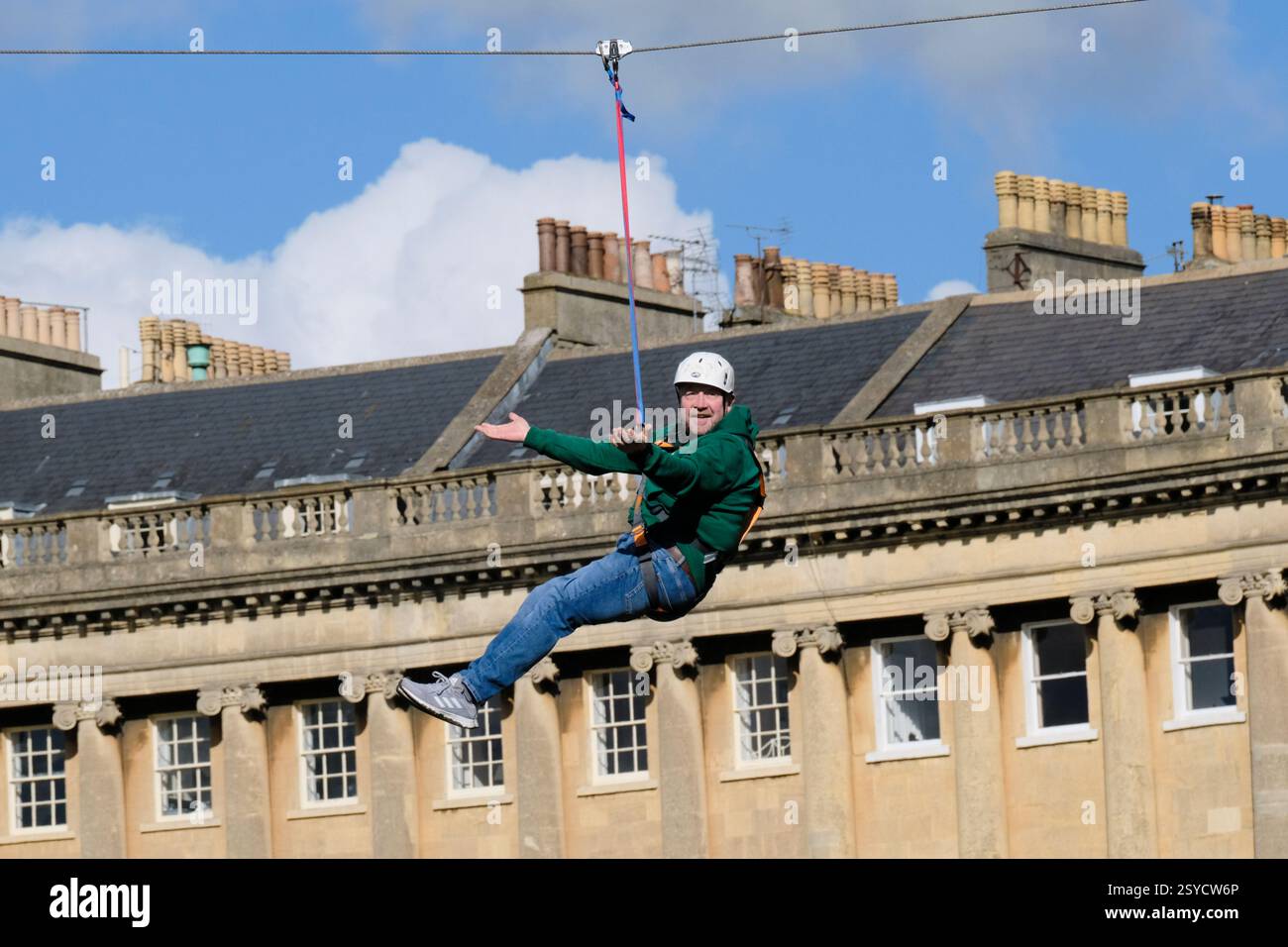 Bath, UK. Februar 2025. Vor dem Royal Crescent im historischen Bath läuft an diesem Wochenende eine Seilrutsche für Wohltätigkeitsorganisationen. Es wird von der Wohltätigkeitsorganisation Dorothy House organisiert, die spezialisierte Pflege am Ende des Lebens, Dorothy House ist durch Spenden. Steigende Preise und zusätzliche Arbeitssteuern haben die Kosten der Wohltätigkeitsorganisation erhöht, und die Seilrutsche wird das Bewusstsein für den finanziellen Druck schärfen und Spenden fördern. Quelle: JMF News/Alamy Live News Stockfoto