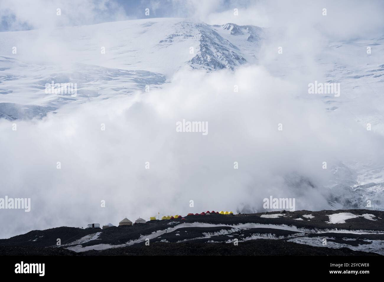 Zeltplatz in großer Höhe mit riesigen schneebedeckten Bergen im Hintergrund, Pamir Mountains, Kirgisistan Stockfoto
