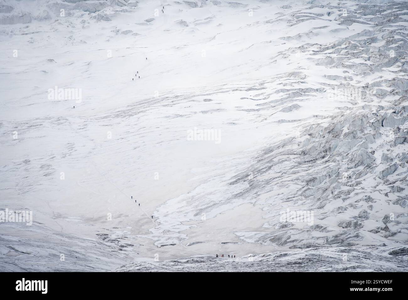 Gruppen von Menschen, die schwieriges Gletschergelände besteigen, weit entfernt vom Pamir-Gebirge, Kirgisistan Stockfoto