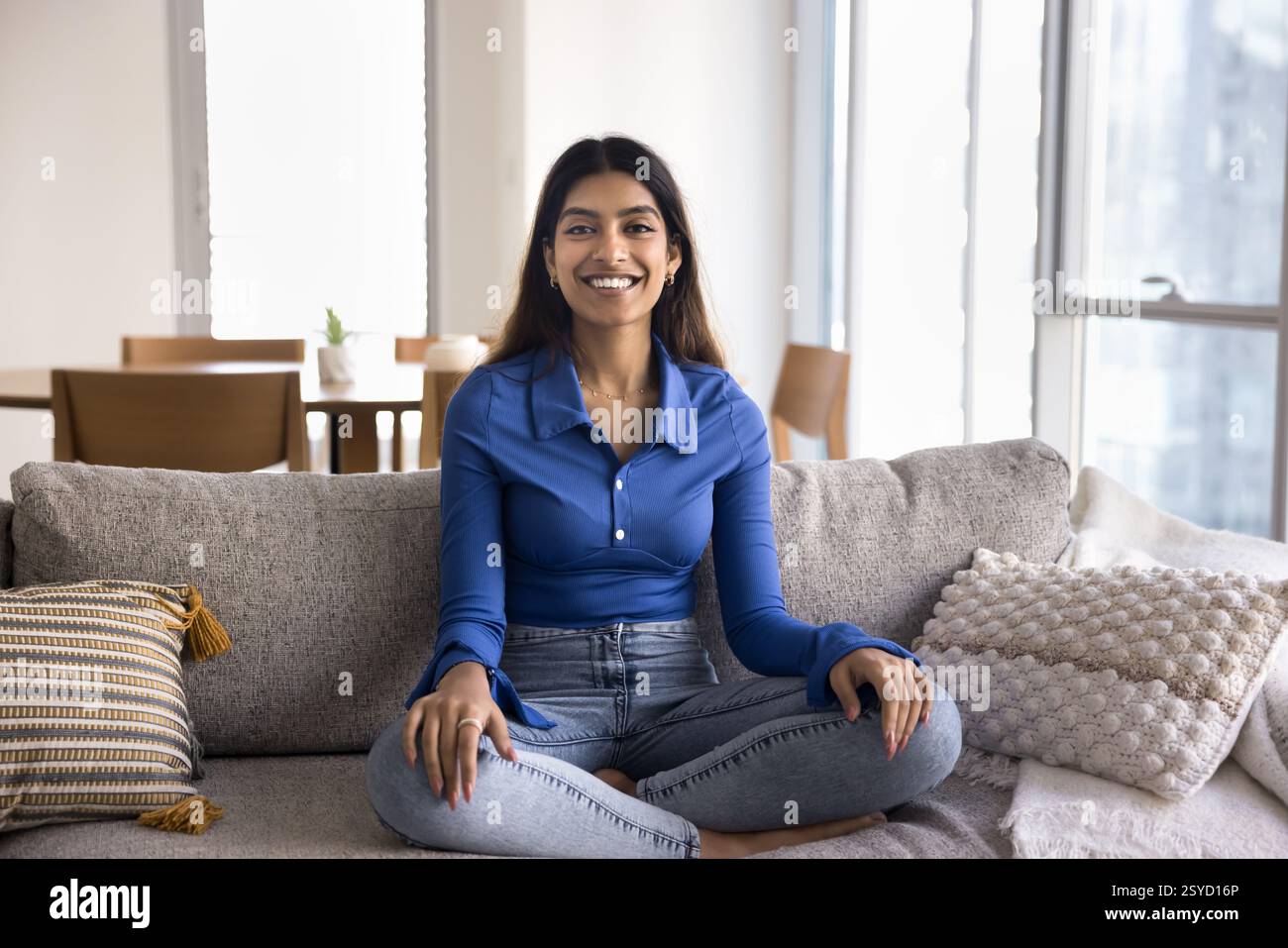 Frau übt Meditation auf Couch, Hausportrait Stockfoto