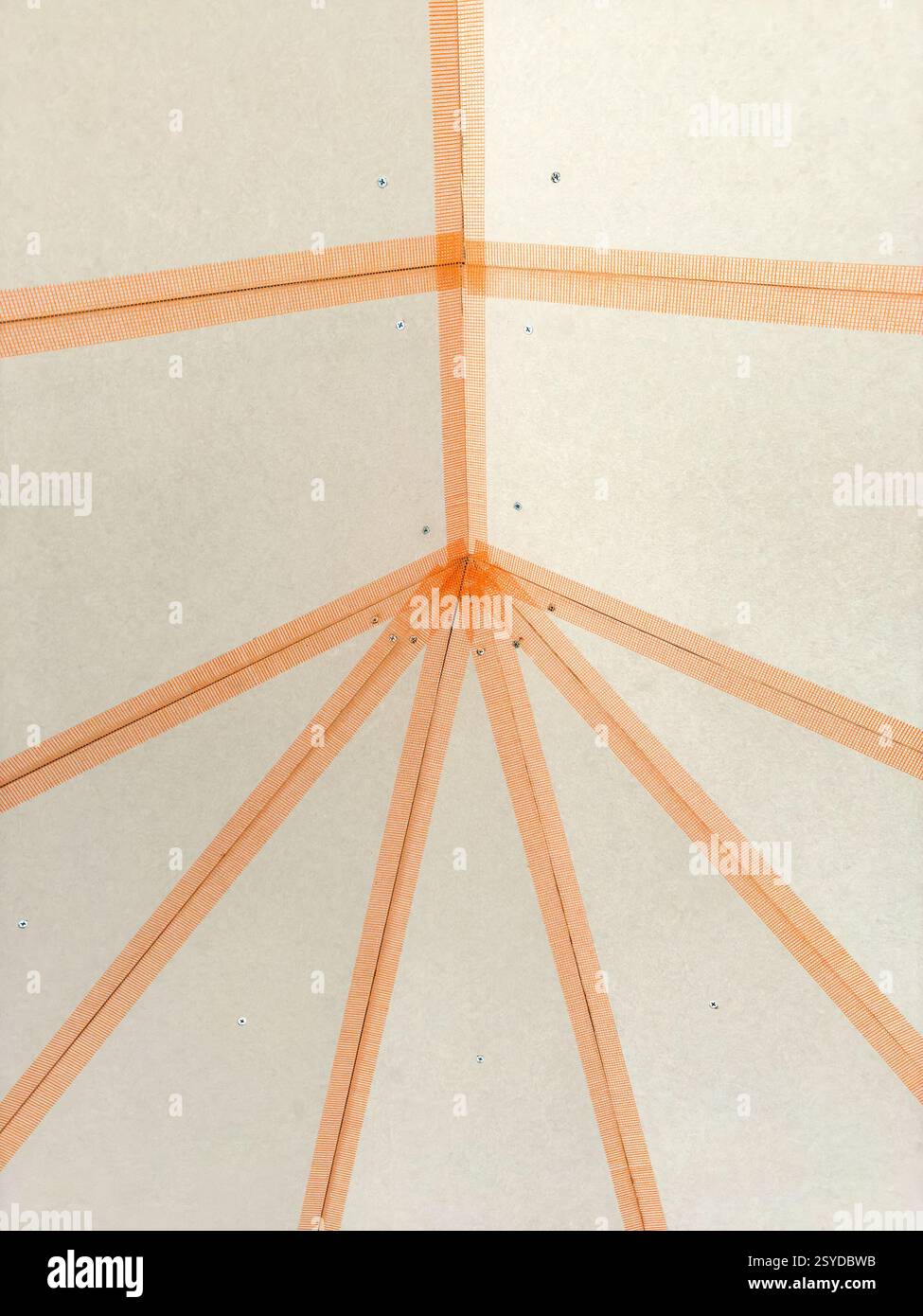 Klebeband an den Fugen von Gipskartonplatten an der Decke eines neuen Wintergartens zur Vorbereitung des Verputzens - Smartphone-aufgenommenes Stockfoto