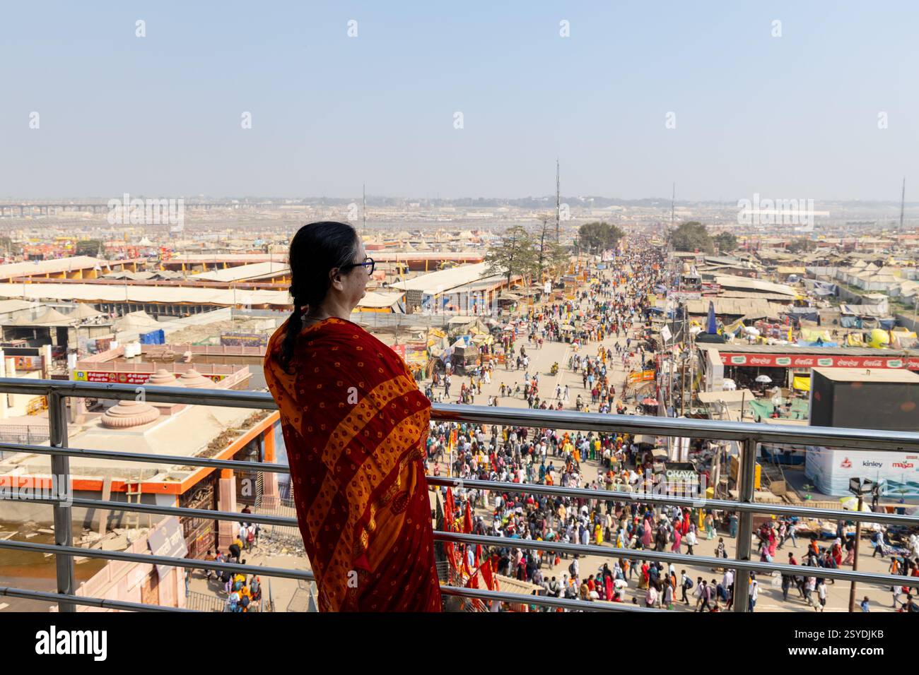 Frauen, die eine riesige Menschenmenge beobachten, die nach triveni Sangam mit temporären Lagern auf dem Mahakumbh Festival zieht, werden im Mahakumbh mela prayagraj uttar prade aufgenommen Stockfoto