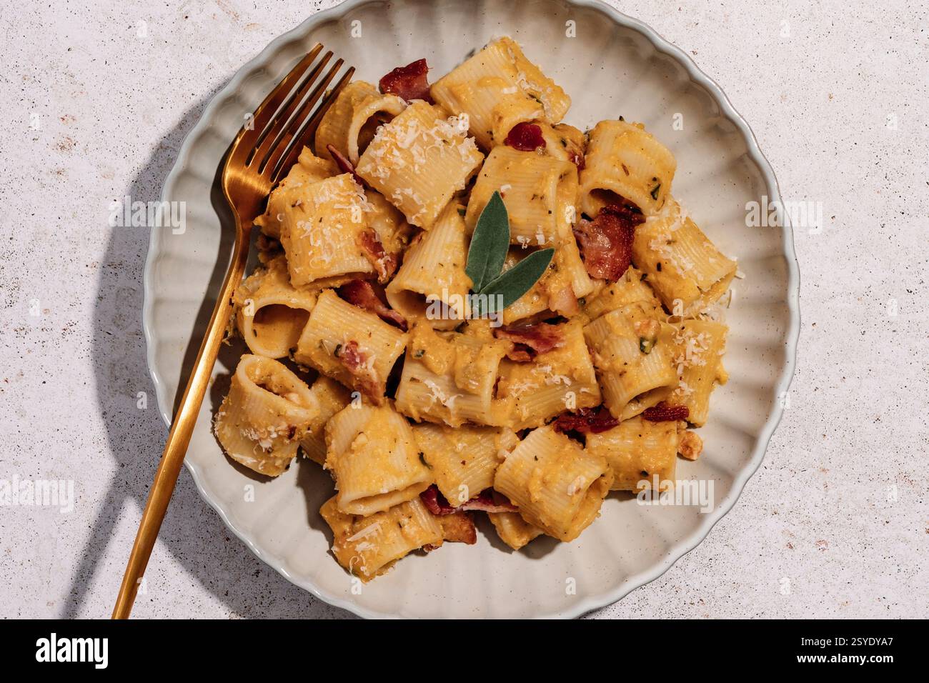 Cremige Butternusskürbis-Pasta mit knusprigem Speck, frischem Salbei und etwas Parmesan Stockfoto