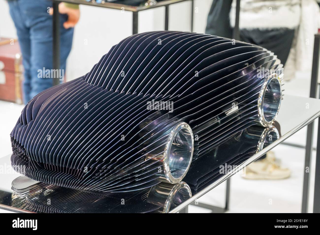 Die elegante Holzskulptur eines Autos zeigt innovatives Design in einer modernen Kunstausstellung in einer belebten städtischen Galerie Stockfoto