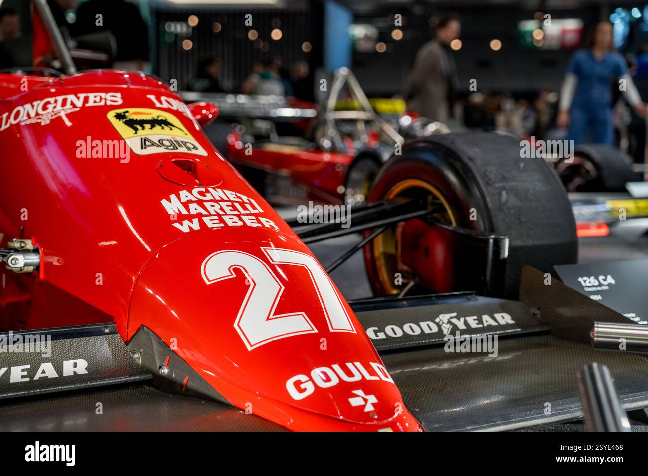 Klassischer Rennwagen mit lebendigem Design auf einer Automobilausstellung in einer geschäftigen Stadt während einer Abendveranstaltung Stockfoto