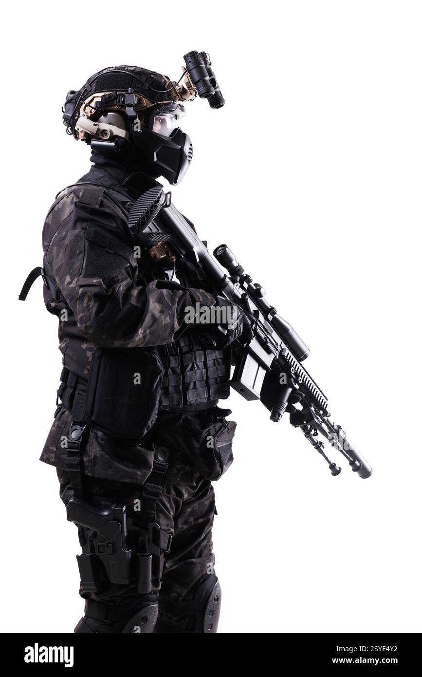 Ein Seitenprofil eines professionellen Soldaten in fortgeschrittener Kampfausrüstung, mit Gewehr, Helm und Schutzmaske. schützen Stockfoto